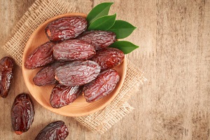 Closeup image of the date of the palm fruit on a sack cloth  background, wood table The date that the dried palm fruit is a healthy snack
