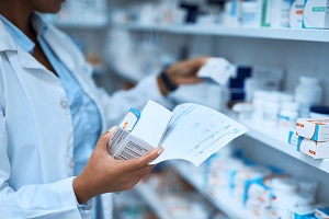 Cropped shot of a pharmacist filling a prescription at a chemist