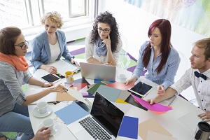 High angle view of businesspeople analyzing photographs in creative office